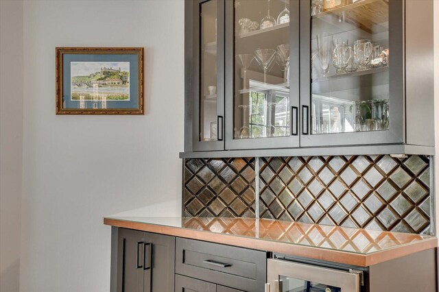 bar with beverage cooler and gray cabinetry