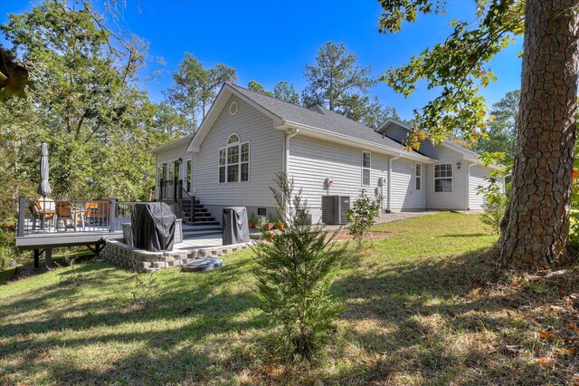 rear view of house featuring a wooden deck and a yard