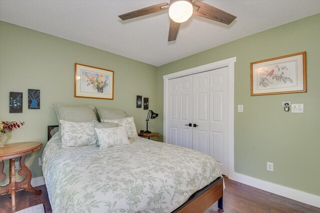 bedroom with dark hardwood / wood-style flooring, a closet, and ceiling fan