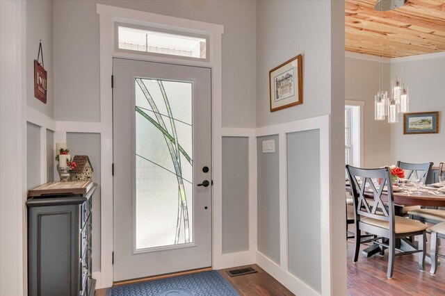 entrance foyer featuring hardwood / wood-style flooring, a notable chandelier, and wood ceiling