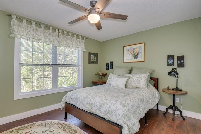 bedroom featuring multiple windows, ceiling fan, and dark hardwood / wood-style floors