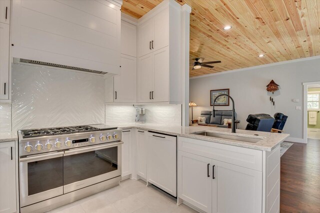 kitchen featuring range with two ovens, kitchen peninsula, sink, and wooden ceiling