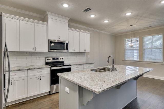 kitchen featuring pendant lighting, white cabinetry, appliances with stainless steel finishes, and a center island with sink