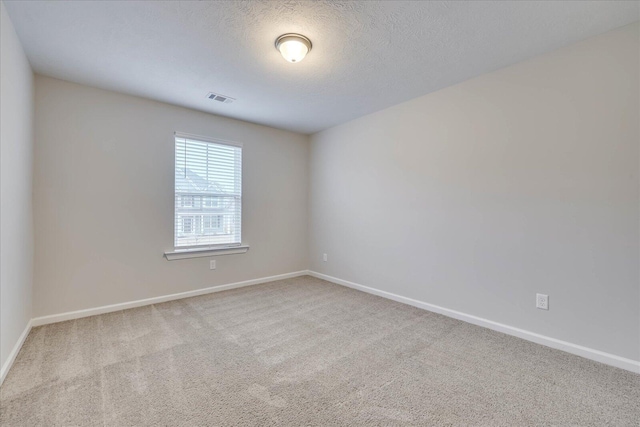 carpeted empty room with a textured ceiling