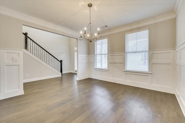 interior space with a notable chandelier, wood-type flooring, and ornamental molding