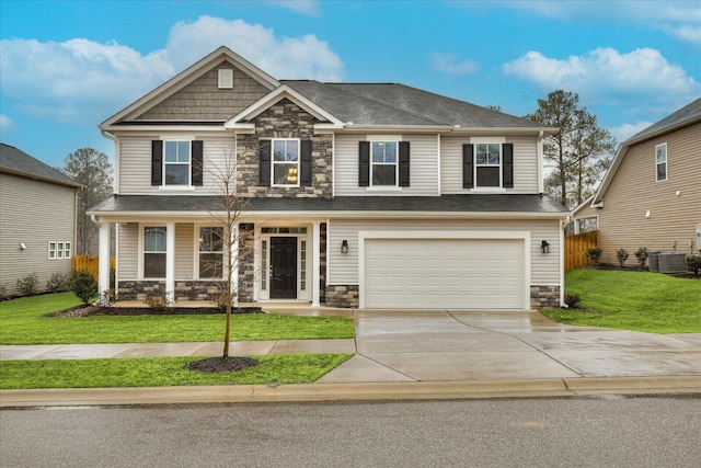 craftsman house featuring a garage, central AC unit, covered porch, and a front lawn