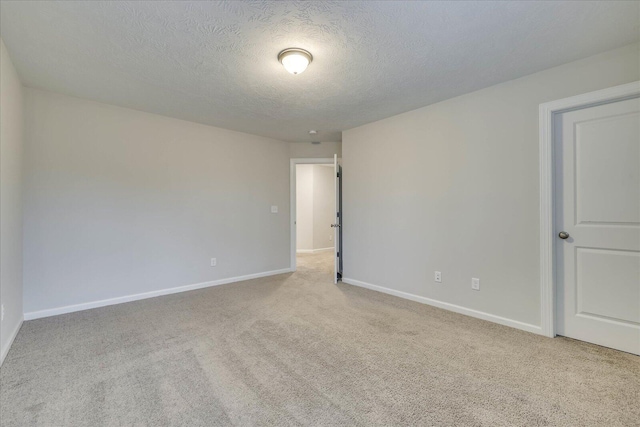 carpeted empty room featuring a textured ceiling