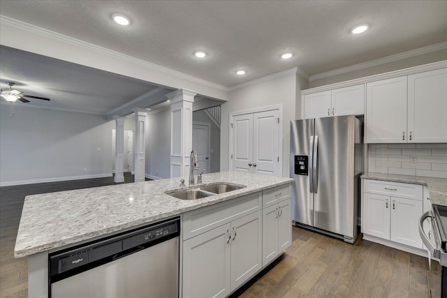 kitchen featuring tasteful backsplash, sink, white cabinets, a kitchen island with sink, and stainless steel appliances