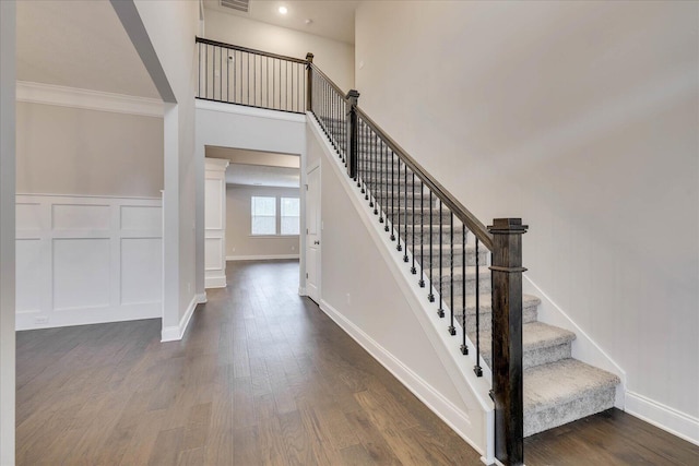 stairs with hardwood / wood-style flooring and crown molding