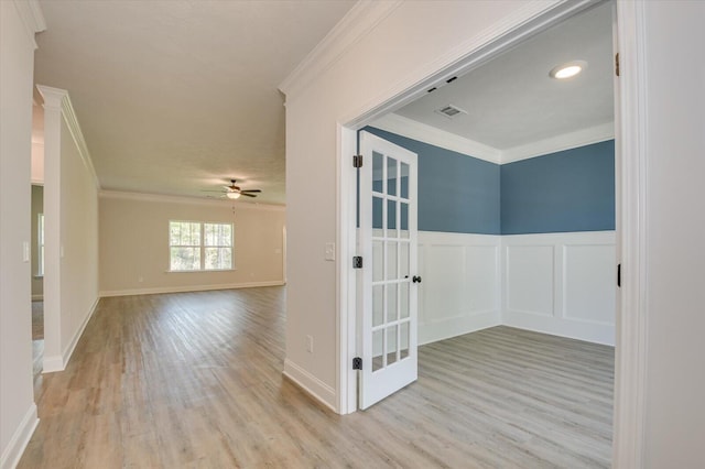 empty room with ceiling fan, light hardwood / wood-style flooring, and ornamental molding