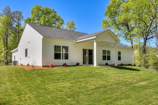 back of property with a yard and central AC unit