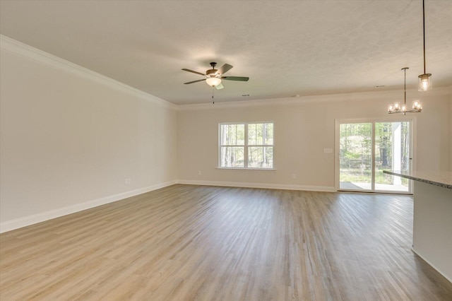 empty room with ceiling fan with notable chandelier, light hardwood / wood-style floors, a wealth of natural light, and crown molding