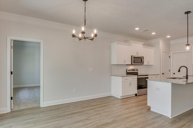 kitchen with appliances with stainless steel finishes, decorative light fixtures, white cabinetry, and sink