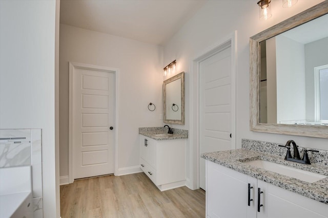 bathroom featuring a tub, hardwood / wood-style floors, and vanity