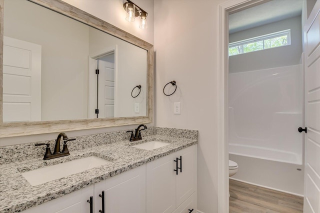 full bathroom with vanity, wood-type flooring, bathtub / shower combination, and toilet