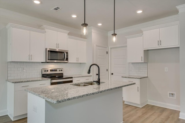 kitchen with white cabinets, decorative light fixtures, stainless steel appliances, and an island with sink