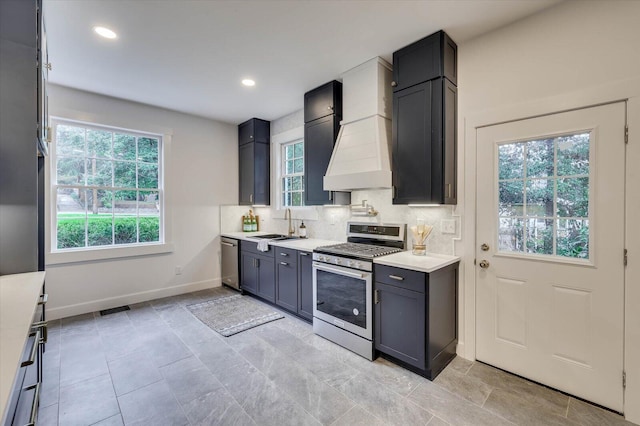 kitchen with sink, custom range hood, stainless steel appliances, and tasteful backsplash