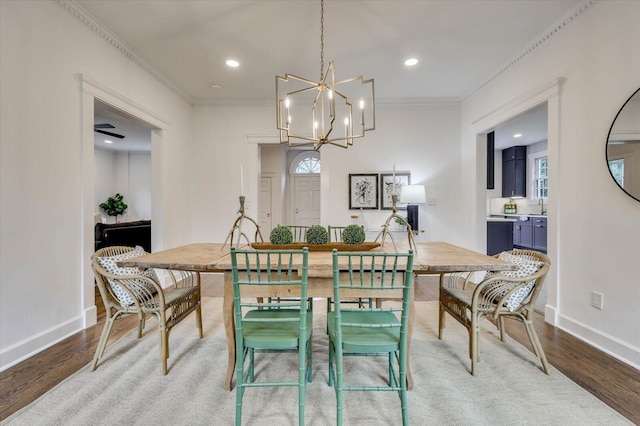 dining space with hardwood / wood-style floors, a notable chandelier, and ornamental molding