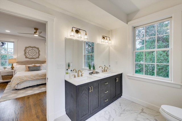 bathroom featuring ceiling fan, wood-type flooring, plenty of natural light, and vanity