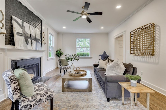 living room featuring hardwood / wood-style flooring, ceiling fan, and ornamental molding