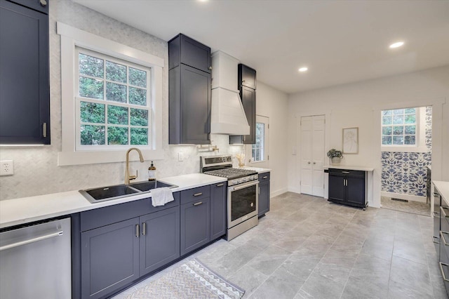 kitchen featuring sink, custom range hood, and stainless steel appliances