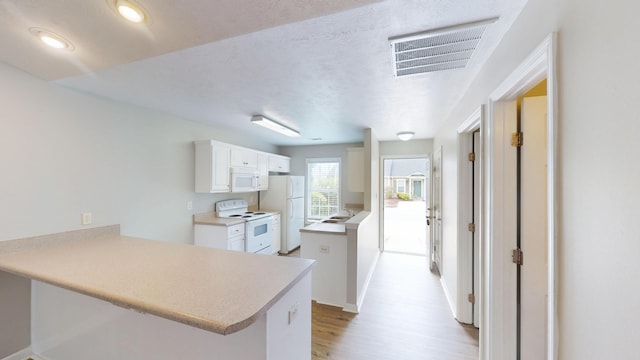 1235 Longpoint Dr, Augusta, GA 30906 - kitchen with visible vents, white appliances, a sink, light wood-type flooring, and a peninsula