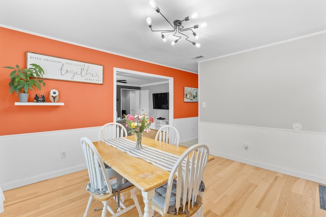 3973 Concord Pl, Martinez, GA 30907 - dining area with crown molding, wood finished floors, wainscoting, and a chandelier