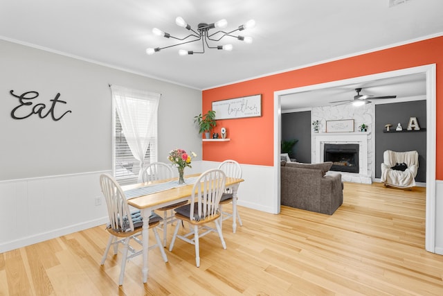 3973 Concord Pl, Martinez, GA 30907 - dining area with wood finished floors, a fireplace, crown molding, wainscoting, and a chandelier