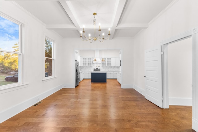 unfurnished dining area featuring ornamental molding, coffered ceiling, beam ceiling, hardwood / wood-style flooring, and a notable chandelier