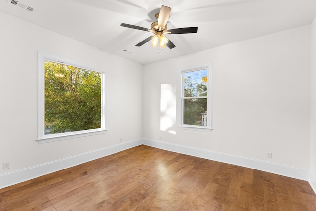 unfurnished room featuring hardwood / wood-style flooring, plenty of natural light, and ceiling fan