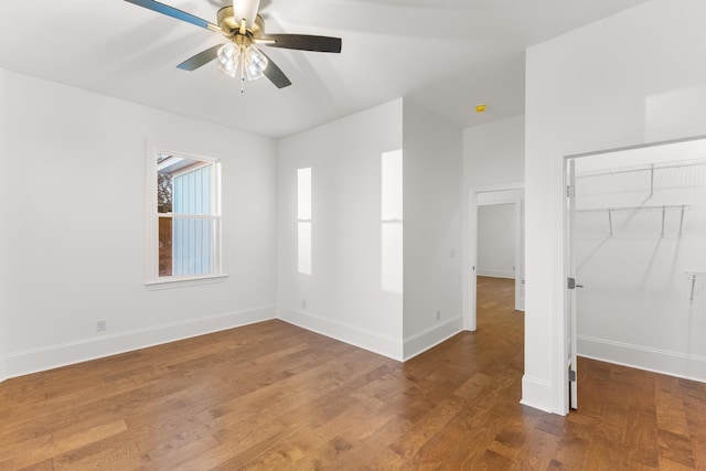 unfurnished bedroom featuring dark hardwood / wood-style flooring, ceiling fan, and a closet