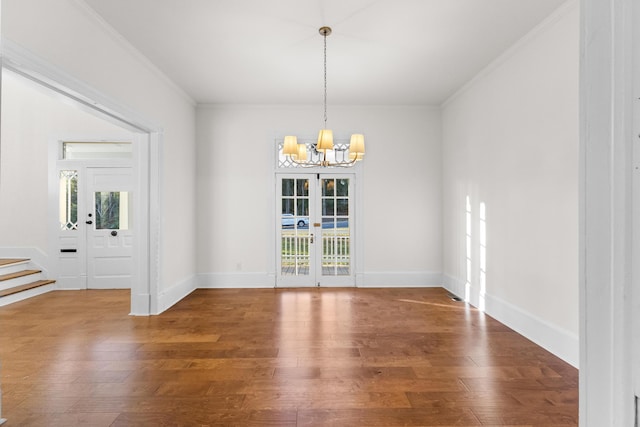 unfurnished dining area with a notable chandelier, wood-type flooring, ornamental molding, and french doors