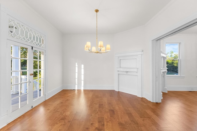 unfurnished dining area featuring crown molding, wood-type flooring, and an inviting chandelier