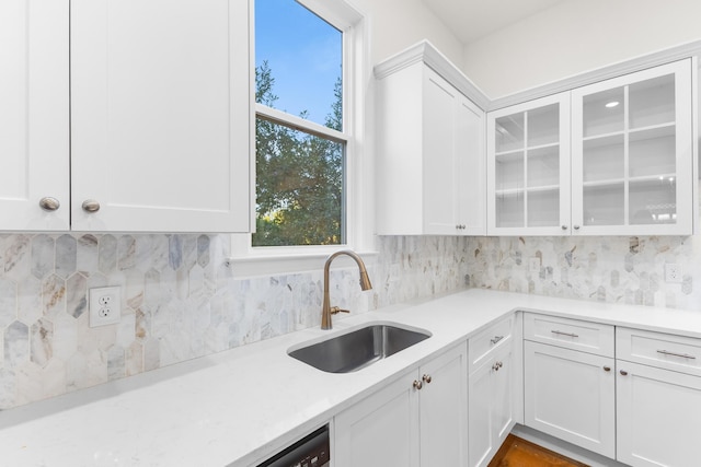 kitchen with white cabinets, backsplash, and sink