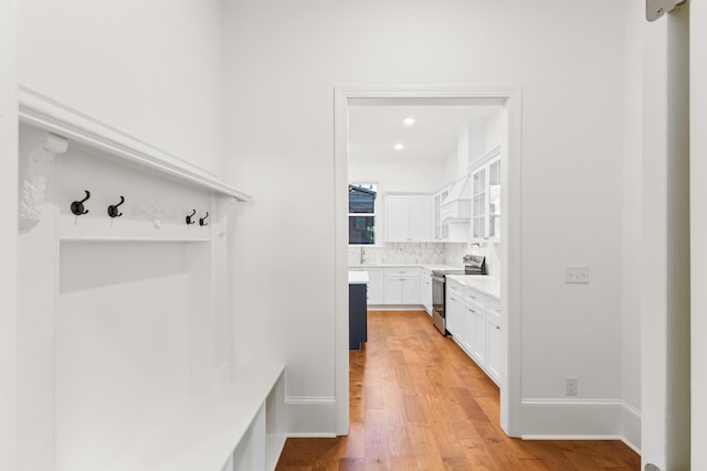 mudroom with light hardwood / wood-style flooring and sink