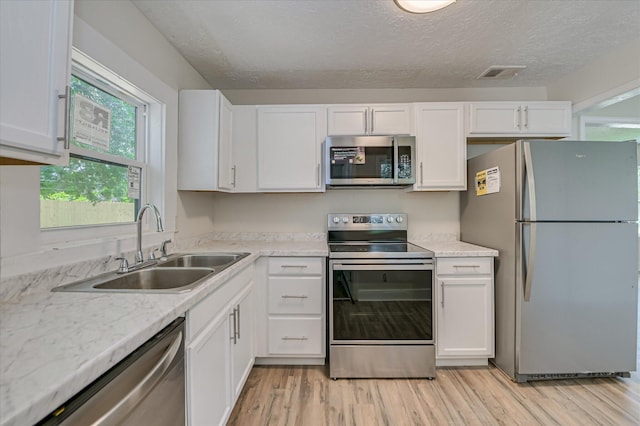 2001 Hiram Rd, Augusta, GA 30904 - kitchen featuring stainless steel appliances, white cabinets, light wood-type flooring, and a textured ceiling
