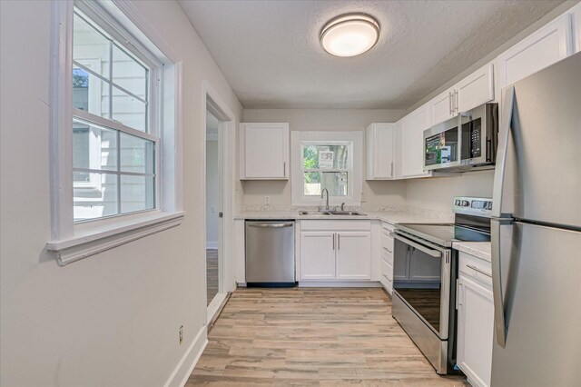 2001 Hiram Rd, Augusta, GA 30904 - kitchen with stainless steel appliances, light wood-type flooring, white cabinets, light countertops, and a textured ceiling