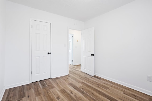 unfurnished bedroom featuring light wood-type flooring and baseboards