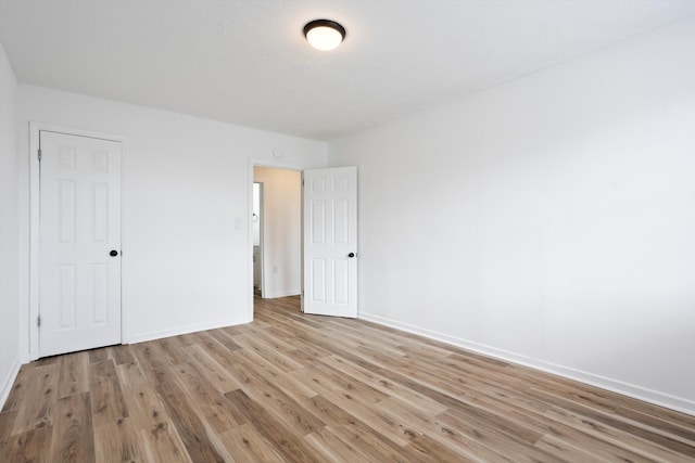 unfurnished bedroom featuring light wood-style flooring and baseboards