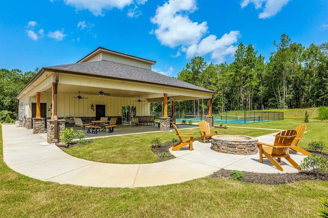 surrounding community with a lawn, tennis court, and a patio