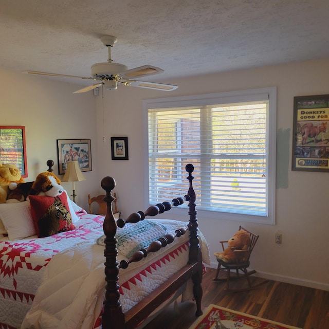 bedroom with baseboards, a textured ceiling, wood finished floors, and a ceiling fan