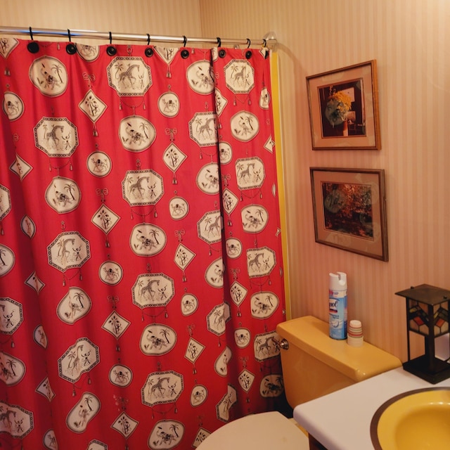 full bath with wallpapered walls, a shower with shower curtain, toilet, and vanity