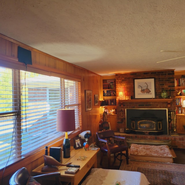 living area with wood walls, a textured ceiling, and ornamental molding