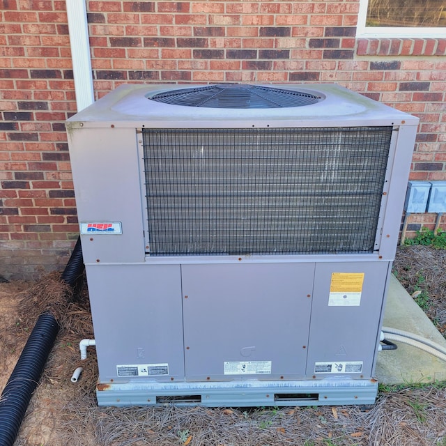 exterior details featuring brick siding and central AC unit