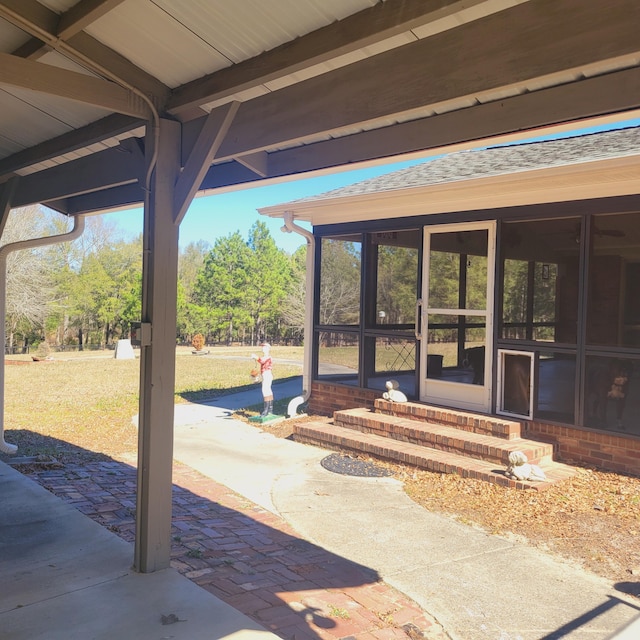 view of patio with entry steps and a sunroom