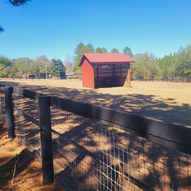 view of road featuring an exterior structure, an outbuilding, and a rural view