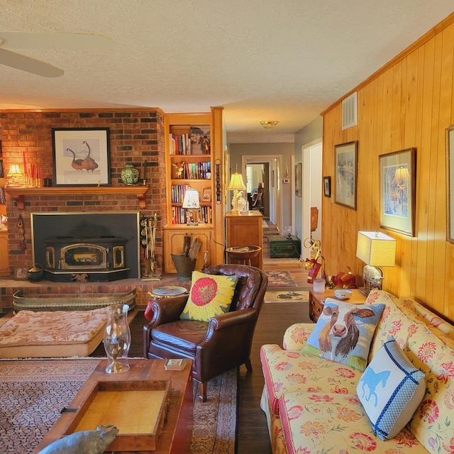 living room featuring visible vents, wood finished floors, a textured ceiling, and wood walls