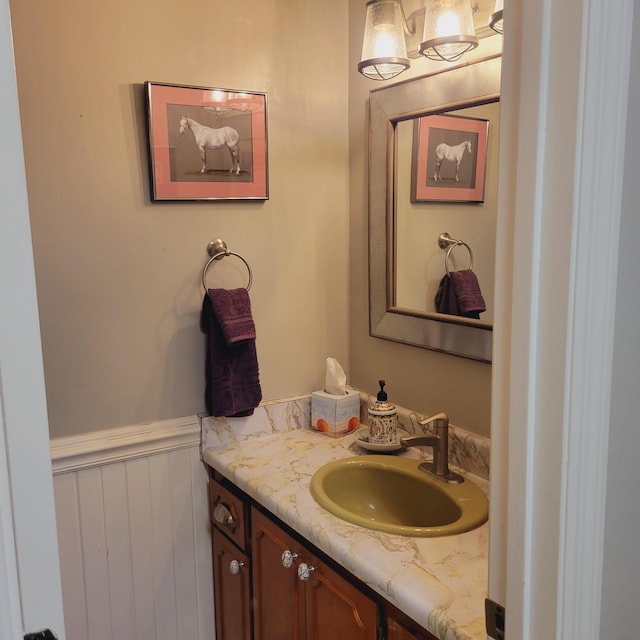 bathroom with vanity and a wainscoted wall