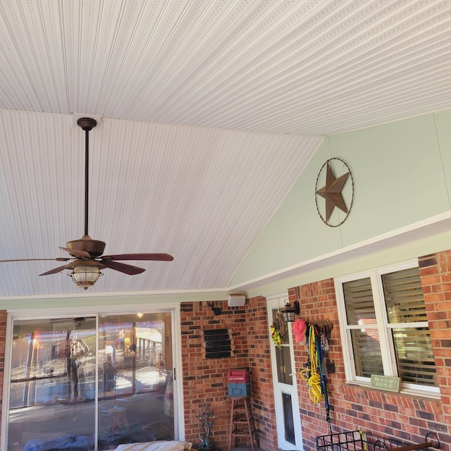 exterior space featuring brick siding and a ceiling fan