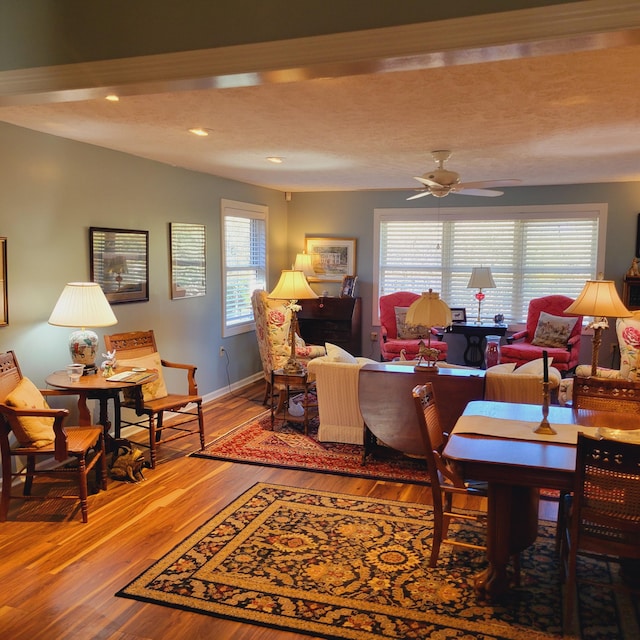 living area featuring a ceiling fan, a textured ceiling, wood finished floors, recessed lighting, and baseboards